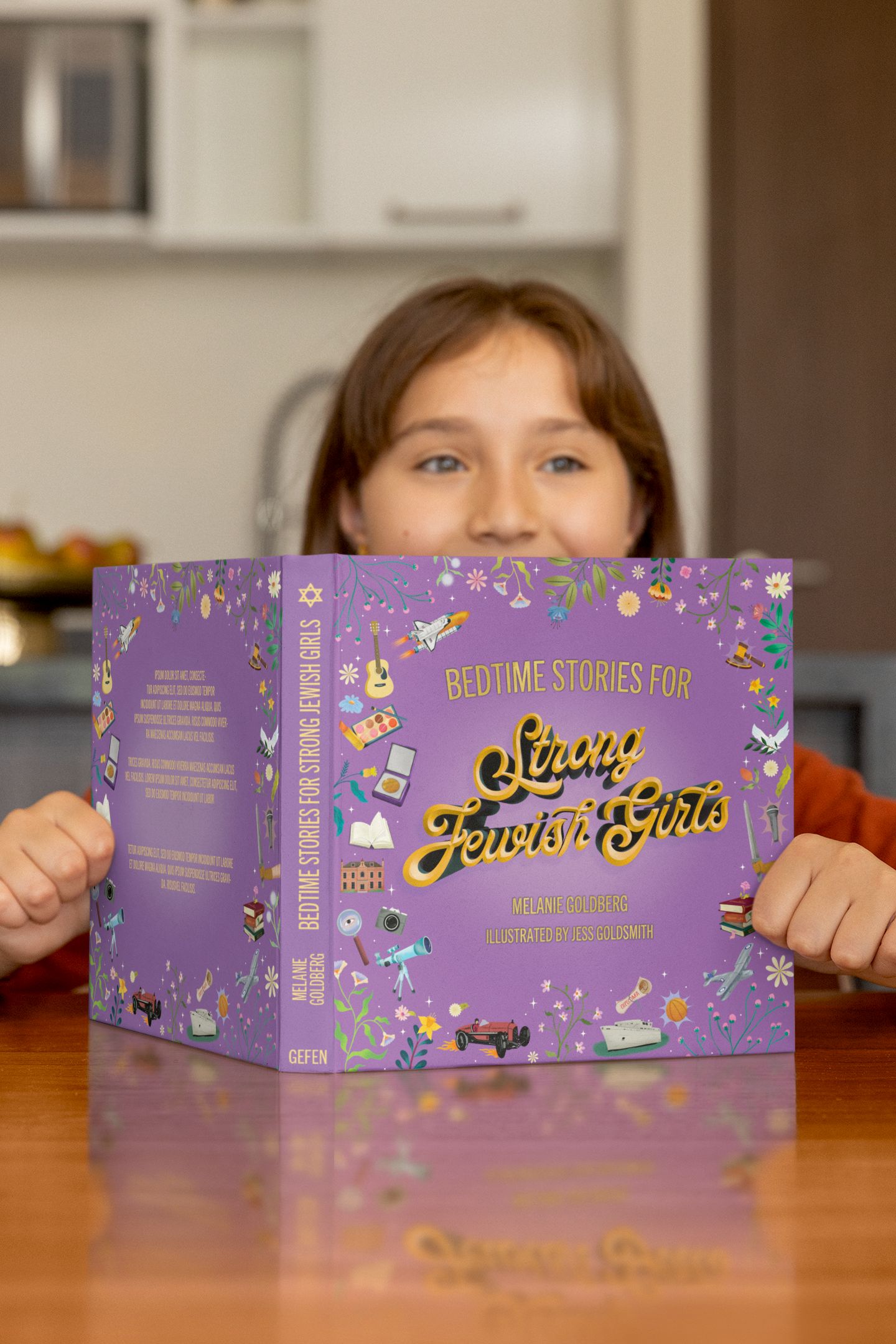 Person holding a purple book titled 'Bedtime Stories for Strange Jewish Girls' in a kitchen setting.